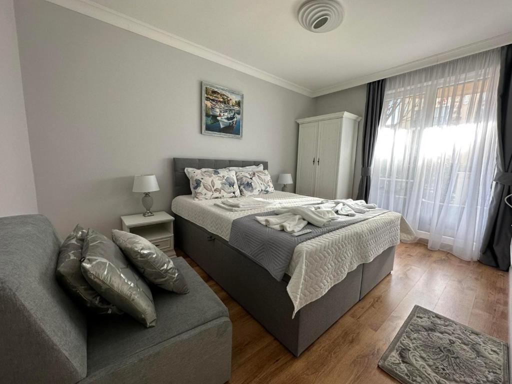 un dormitorio con una cama y un sofá en MARINA Apartments, en Ravda