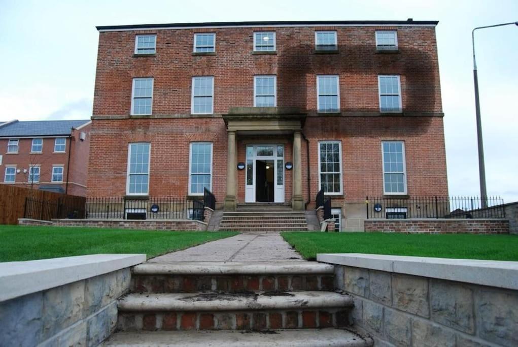 a large brick building with a staircase in front of it at Apartment 20 min walk from Manchester City Centre in Manchester