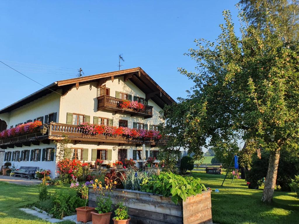 a house with flowers on the side of it at Schneiderhof Ferienwohnung mit Alpenblick in Fischbachau