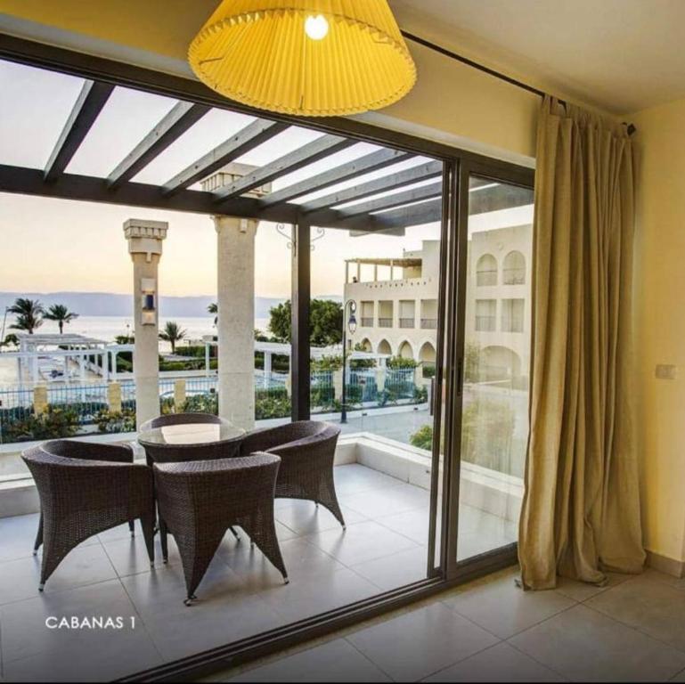 a dining room with a table and chairs on a balcony at Rose Beach Chalet in Aqaba