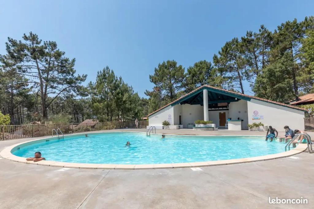 a large swimming pool with people playing in it at Pretty house with double terrace near the ocean in Moliets-et-Maa