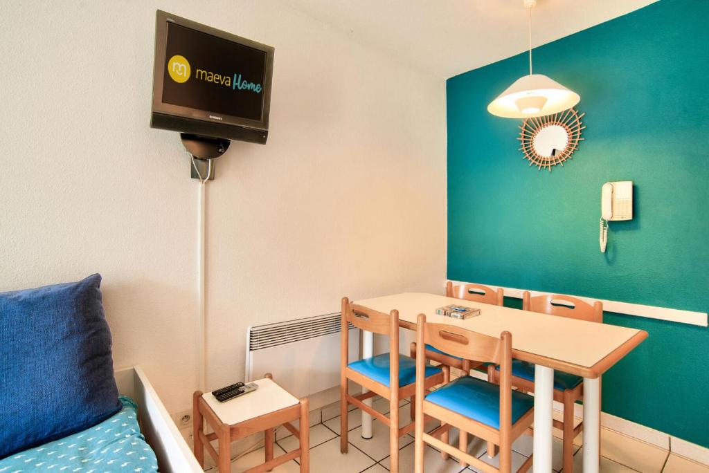 une petite salle à manger avec une table et des chaises dans l'établissement Village Moliets - maeva Home - Studio 5 personnes - Budget MAE-4984, à Moliets-et-Maa