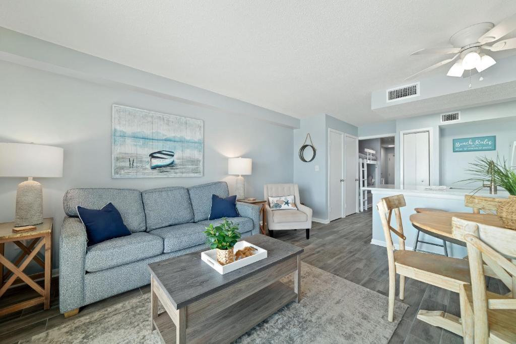 sala de estar con sofá azul y mesa en Seacrest 507, en Gulf Shores