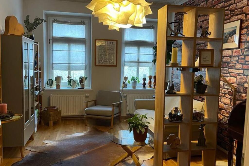 ein Wohnzimmer mit einem Sofa und einem Stuhl in der Unterkunft Gemütliche Wohnung in Gohlis in Leipzig