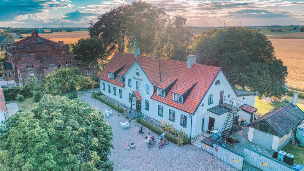 una vista aérea de una gran casa blanca con gente de pie fuera en Hammenhögs gästgivaregård en Hammenhög