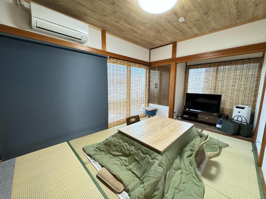 un soggiorno con tavolo e TV di CalmbaseGARAGE - Vacation STAY 50325v a Izu