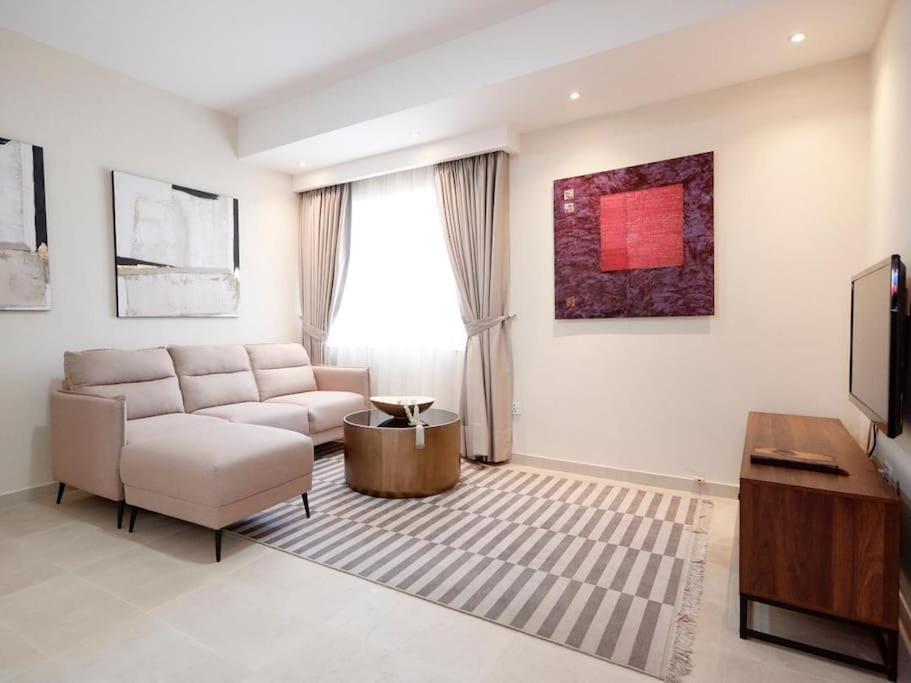 a living room with a couch and a tv at Stylish 2 Bedroom in Osu in Accra