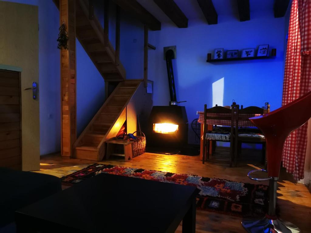 ein Wohnzimmer mit einem Holzofen in einem Zimmer mit einem Tisch in der Unterkunft Markov konak in Jahorina
