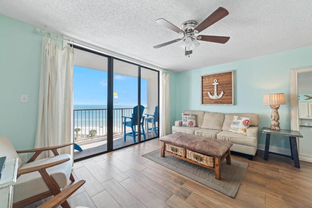 ein Wohnzimmer mit einem Sofa und einem Deckenventilator in der Unterkunft Seaside Beach & Racquet Club 4711 in Orange Beach