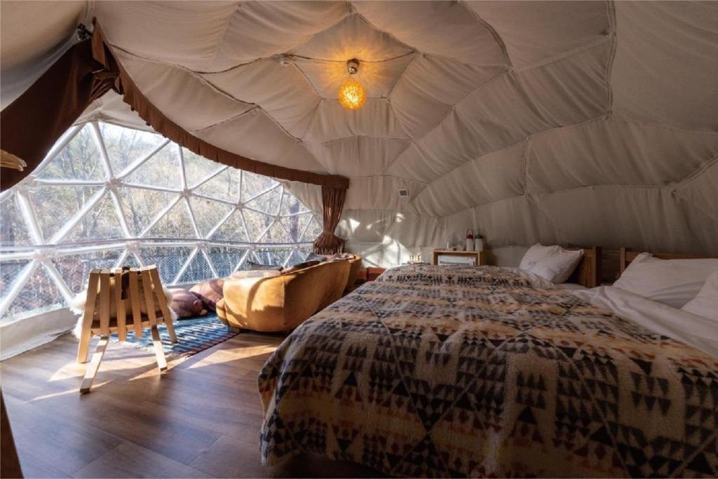 - une chambre avec un lit dans une tente dans l'établissement Hoko Glamping - Camp - Vacation STAY 51102v, à Nakatsugawa