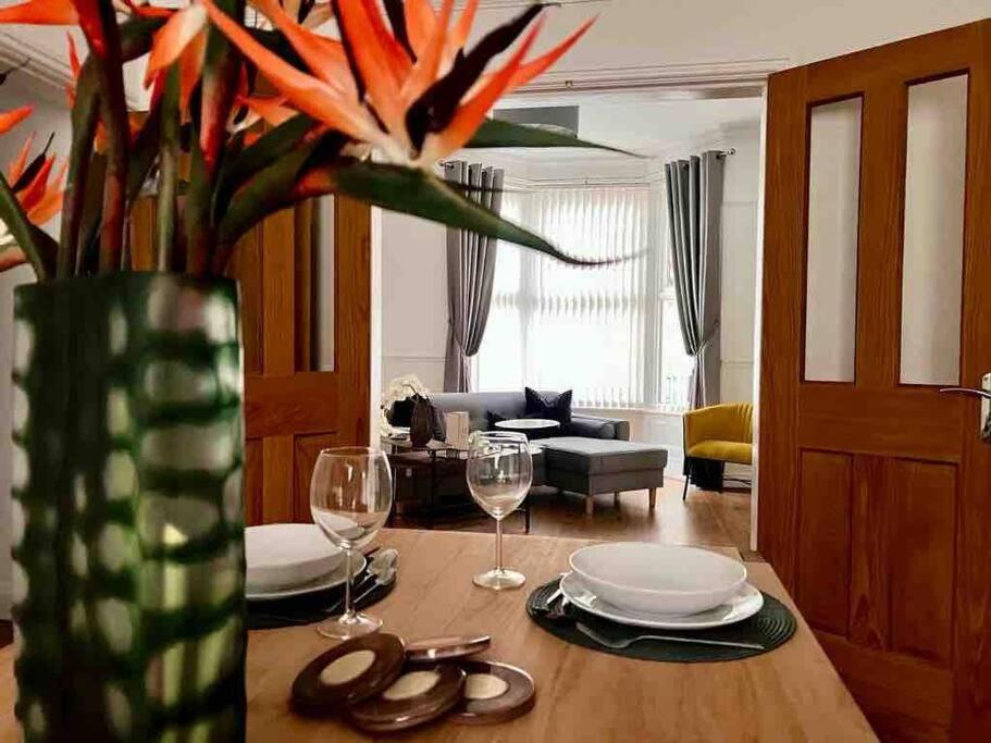 a living room with a table with a vase with flowers at Anfield Home Sleeps 5 Close to LFC free parking in Liverpool