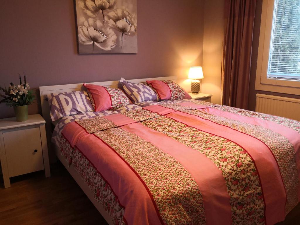 a bedroom with a large bed with colorful sheets and pillows at Coolt Oxie in Oxie
