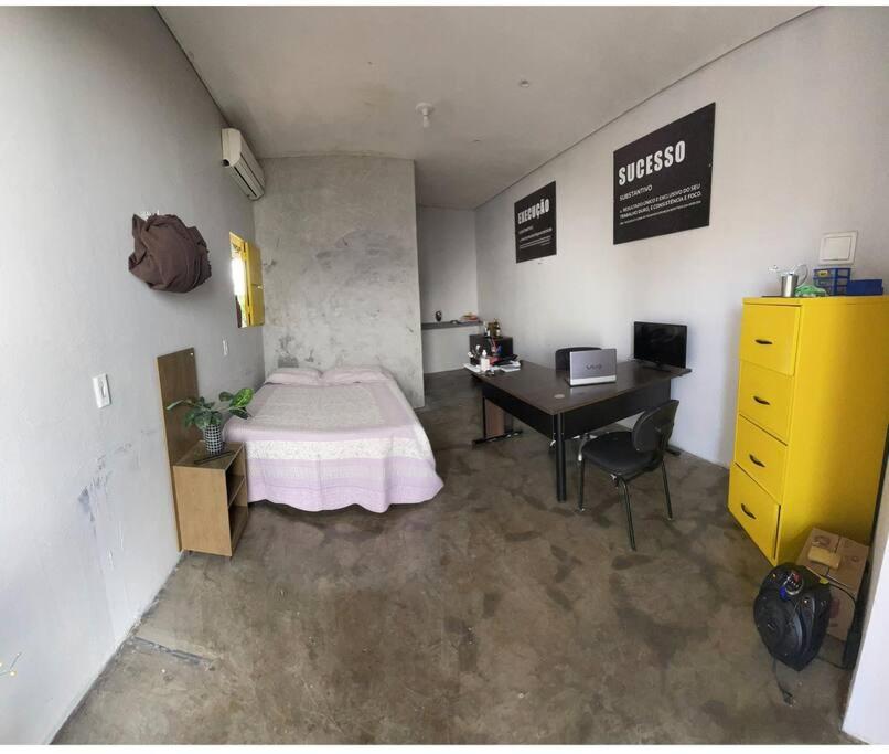 ein Schlafzimmer mit einem Bett und einem Schreibtisch in einem Zimmer in der Unterkunft Seu lar Fora de Casa! in Juazeiro do Norte