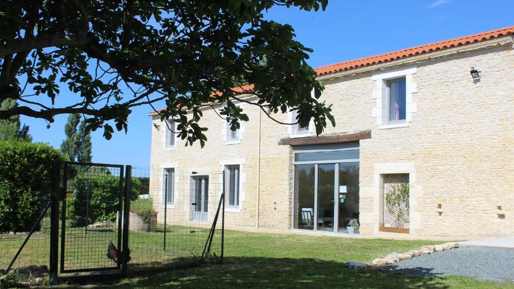 une maison avec une clôture devant un bâtiment dans l'établissement Flore des Marais, à Vix