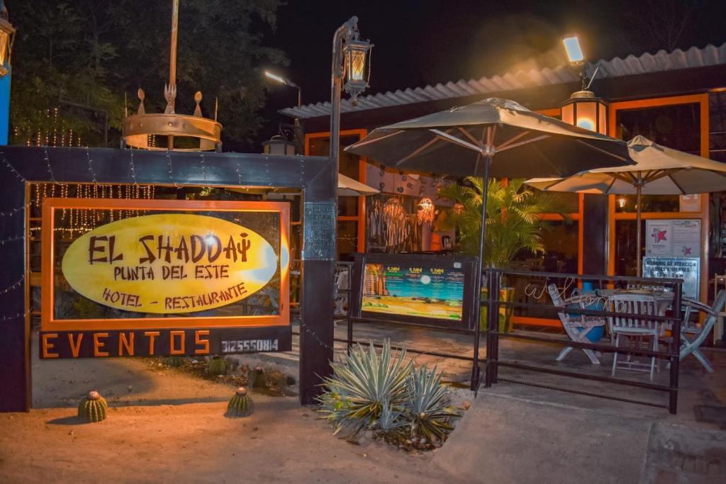 an outdoor restaurant with an umbrella and a pool at Hotel Shaddai in Villavieja