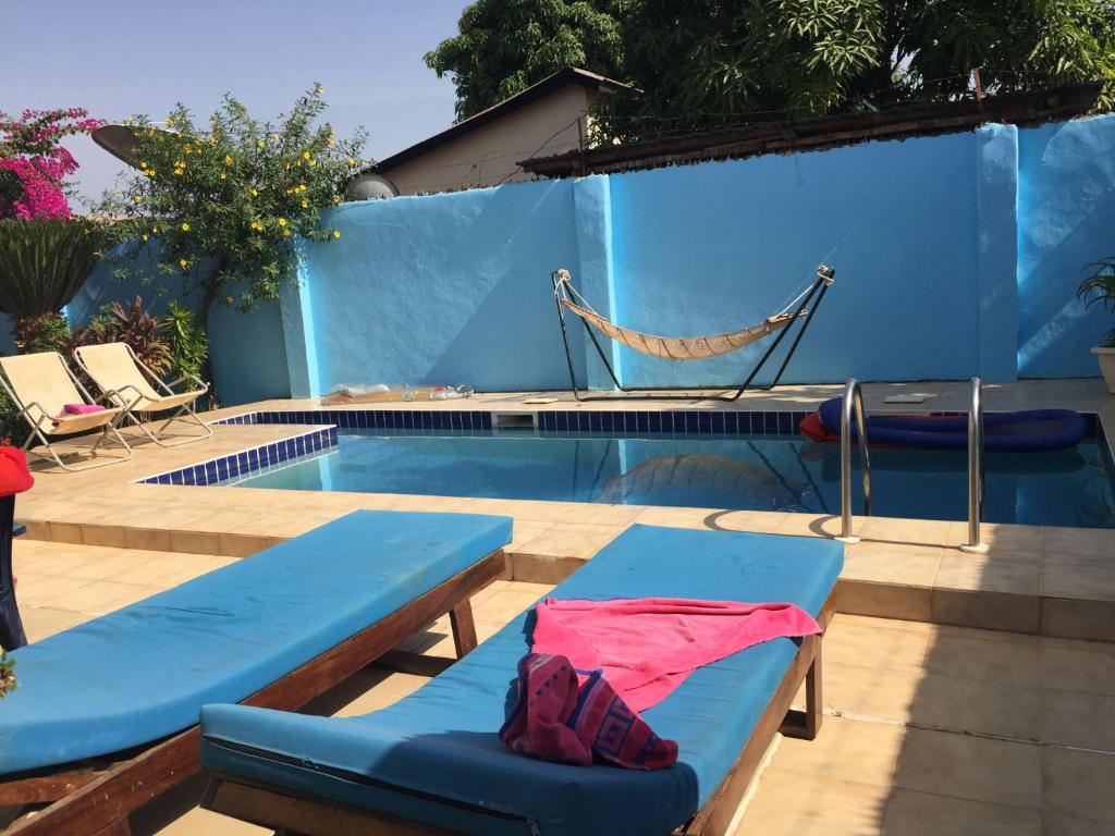 uma piscina com uma parede azul e uma rede ao lado em Banana Republic em Old Yundum