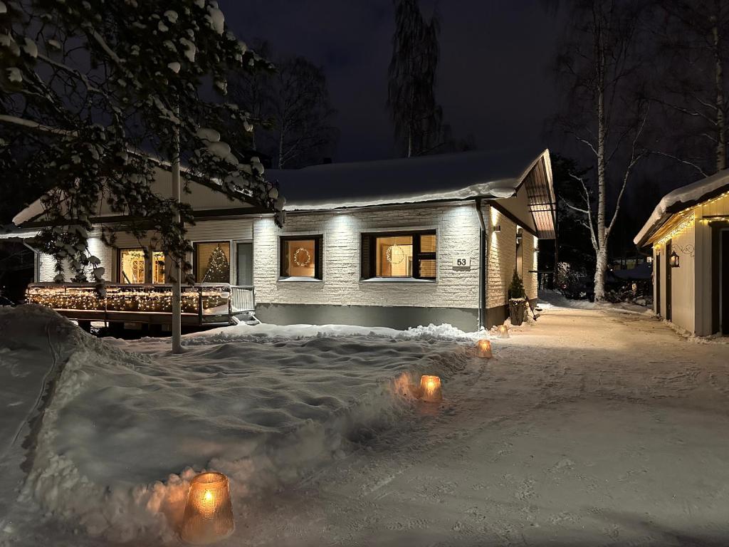 une maison dans la neige la nuit dans l'établissement Villa Kataja, à Rovaniemi