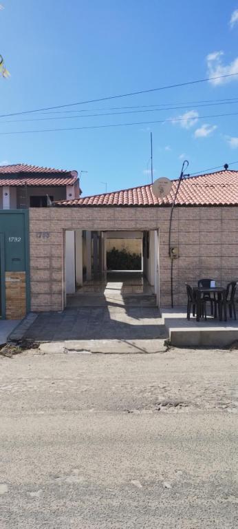 a building with a table and chairs in front of it at Casa em Paracuru in Paracuru