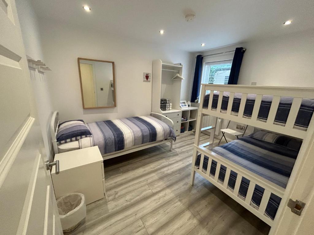 a bedroom with two bunk beds and a mirror at Ballycastle, Beachside Apartment in Ballycastle