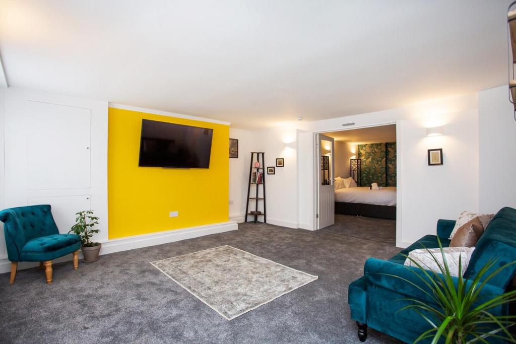 a living room with a couch and a yellow wall at Stephenson's Lodge - Stylish One Bed - City Centre in Sunderland