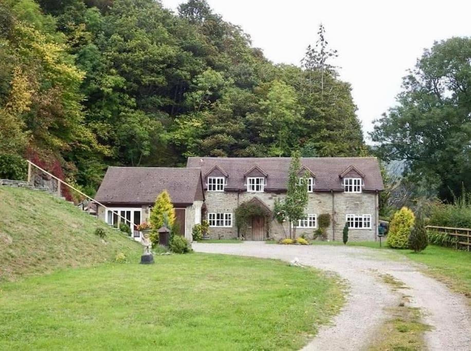 een groot stenen huis met een grindoprit bij Quarry House in Presteigne