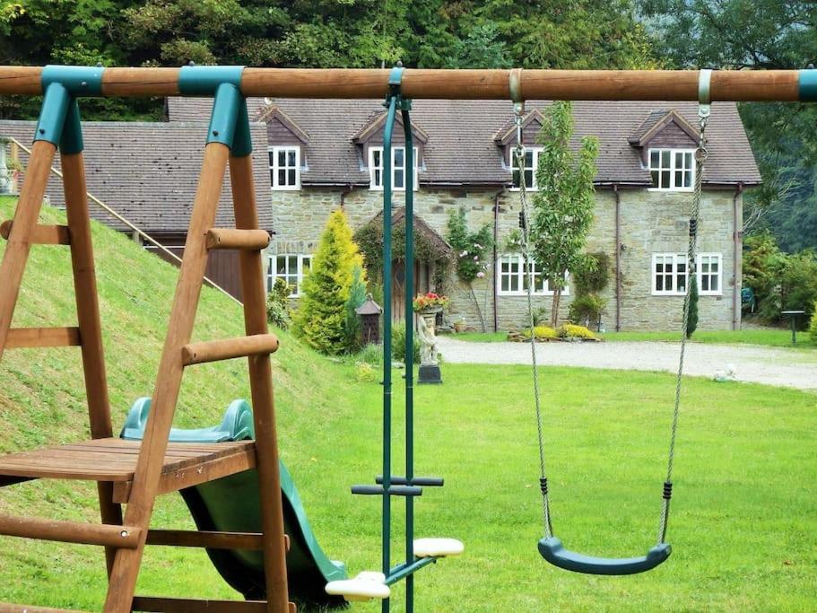 a swing in a yard with a house at Quarry House in Presteigne