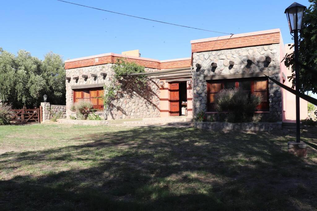une maison en briques avec une cour devant elle dans l'établissement Los Abuelos, à Anillaco