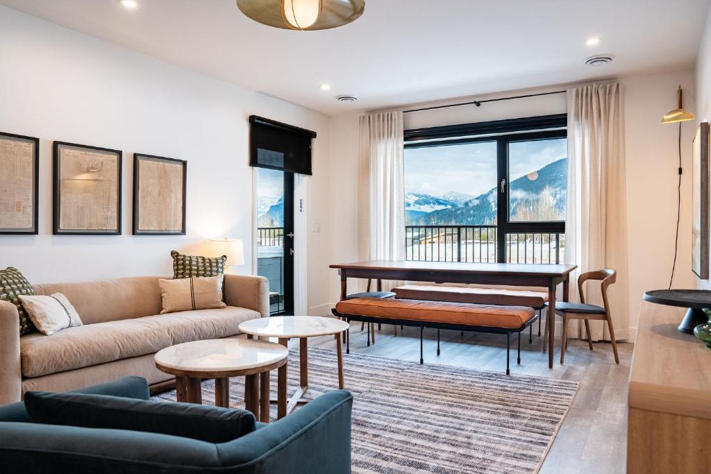 een woonkamer met een bank en een piano bij Escape to Revy - Beautifully Designed Condo in Revelstoke