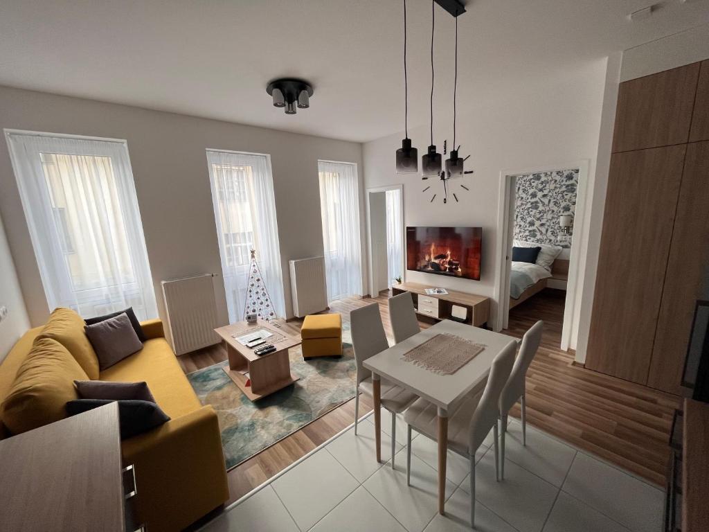 a living room with a couch and a table at One Step Apartman - City Center with Self Check-In in Szombathely