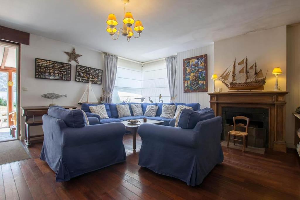 - un salon avec des canapés bleus et une cheminée dans l'établissement CARNAC-Plage 12 personnes à 2mn à pied de la plage, à Carnac