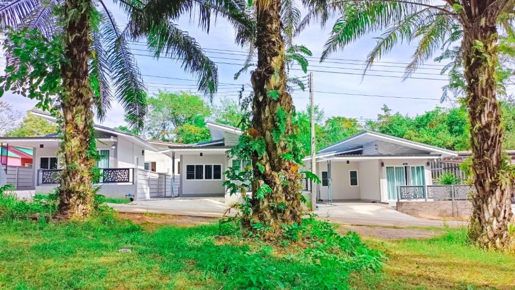 a house with palm trees in front of it at The Engineer's Villas, Krabi in Ban Khlong Chi Lat