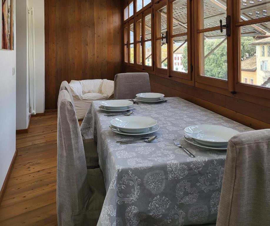 a dining room with a table and chairs with plates at La Casa dei Turchi in Rovereto