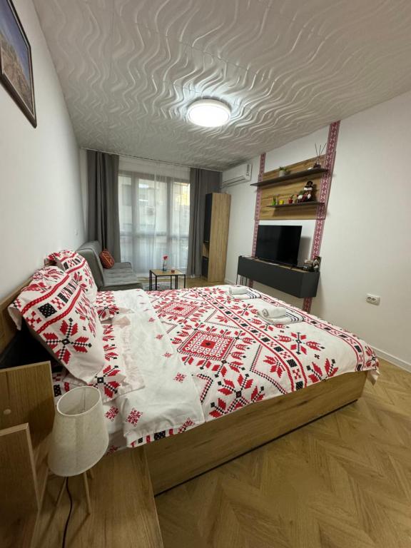 a bedroom with a bed with a red and white blanket at Apartment Studio Shevitsa 2 in Veliko Tŭrnovo