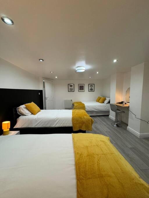 a hotel room with two beds with yellow blankets at Your Home-Big offers for Groups! in Leeds