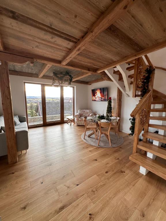 una gran sala de estar con techos de madera y una mesa. en Domek IGNAC, en Ostrowsko
