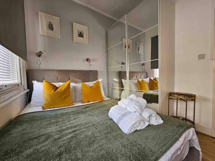 a bedroom with a large bed with yellow pillows at Beautiful and spacious flat in London