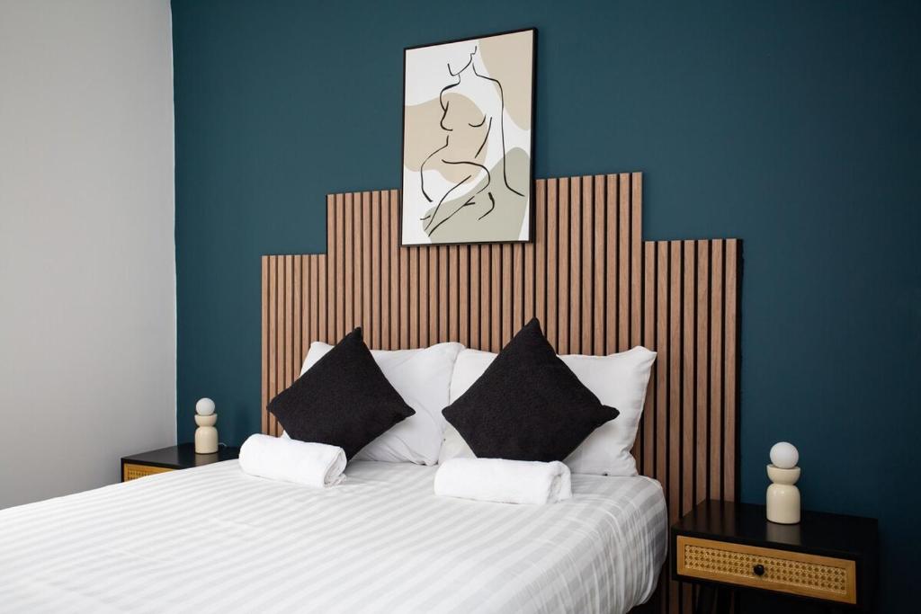 The Burnopfield في Burnopfield: غرفة نوم مع سرير مع وسائد سوداء وبيضاء