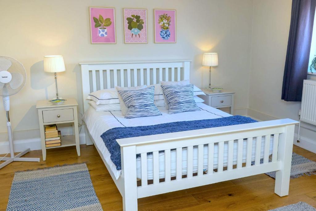 a white bed in a bedroom with two night stands at Entire Apartment in Central Brockenhurst in Brockenhurst