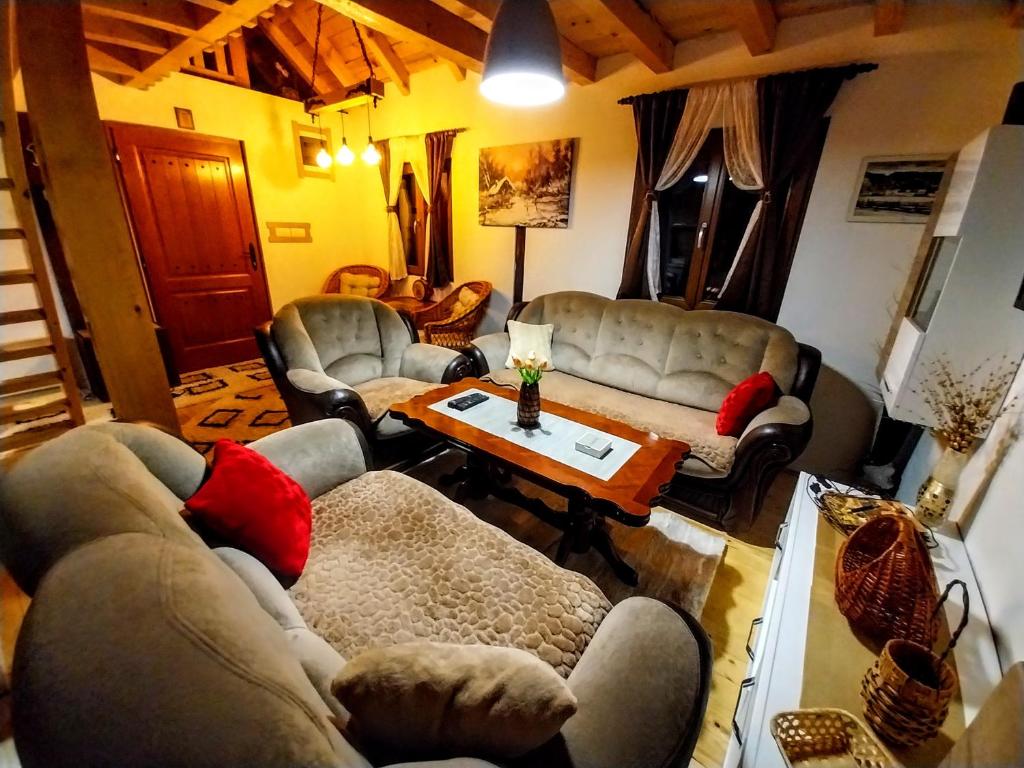 a living room with couches and a coffee table at Planinska kuća MESECEV PUT in Bajina Bašta
