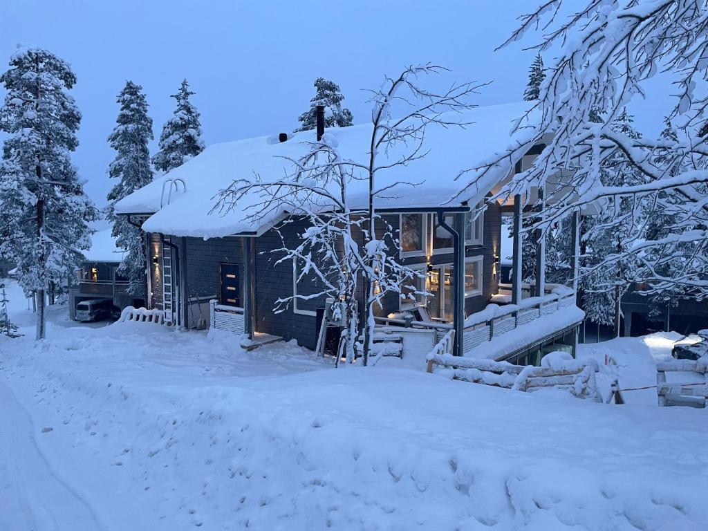 a house covered in snow in the yard at Holy Moly in Pelkosenniemi