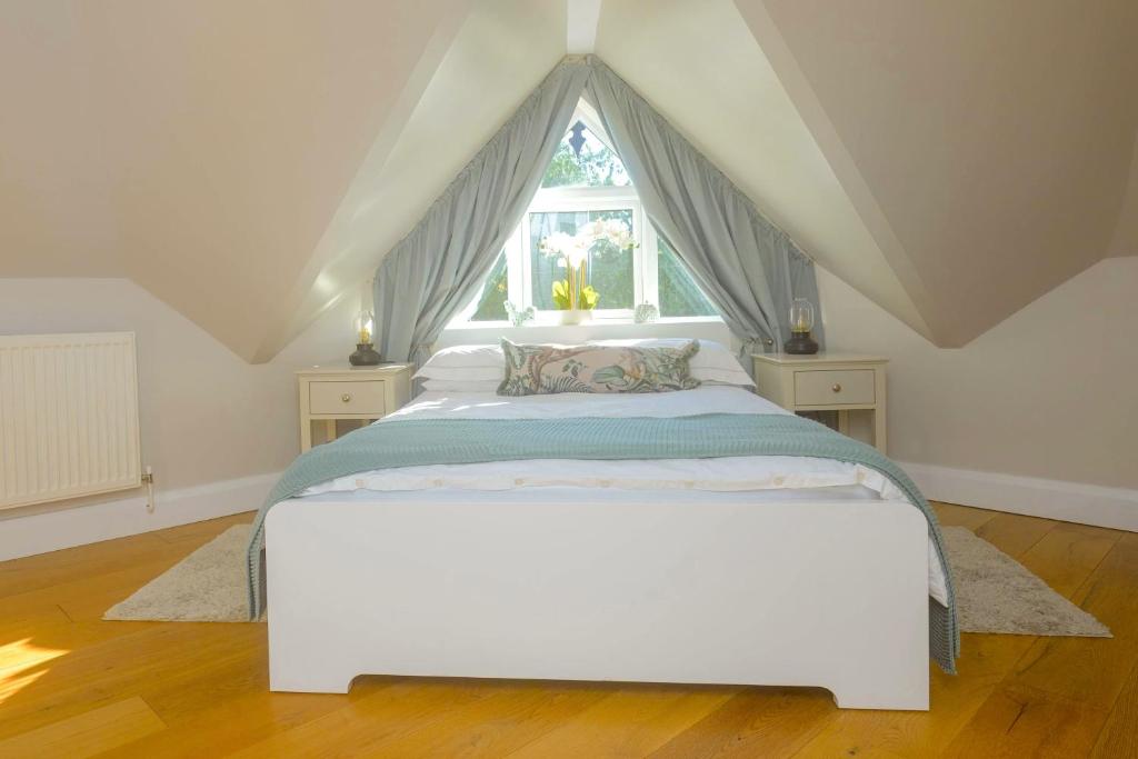 Cama blanca en habitación con ventana en Entire Apartment in Central Brockenhurst en Brockenhurst