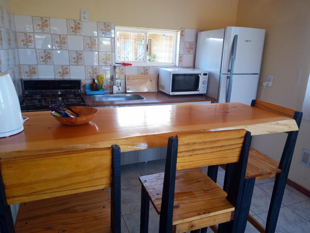 uma cozinha com uma mesa de madeira e um frigorífico em El Llanqui em San Carlos de Bariloche