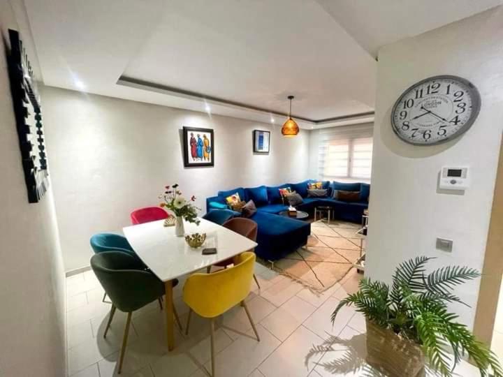 a living room with a table and a clock on the wall at Résidence lina in Casablanca