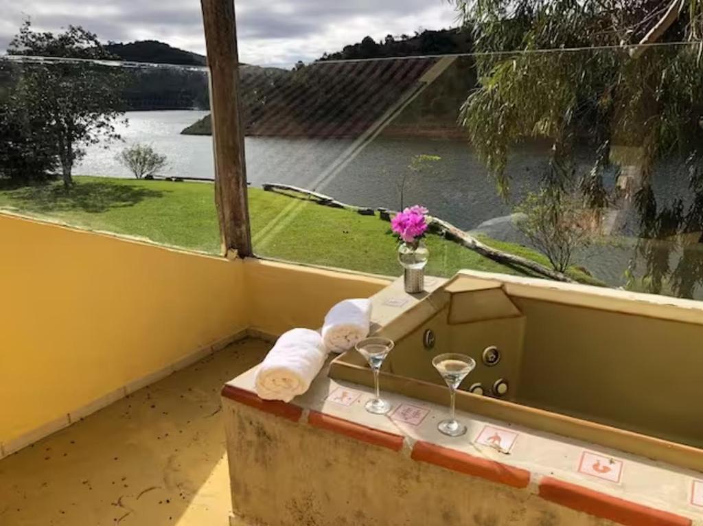 a bath tub with a window with a view of a river at Casa Apu Honey Moon Suite Pague duas noites minimo e a terceira e brinde menos feriados in Natividade da Serra