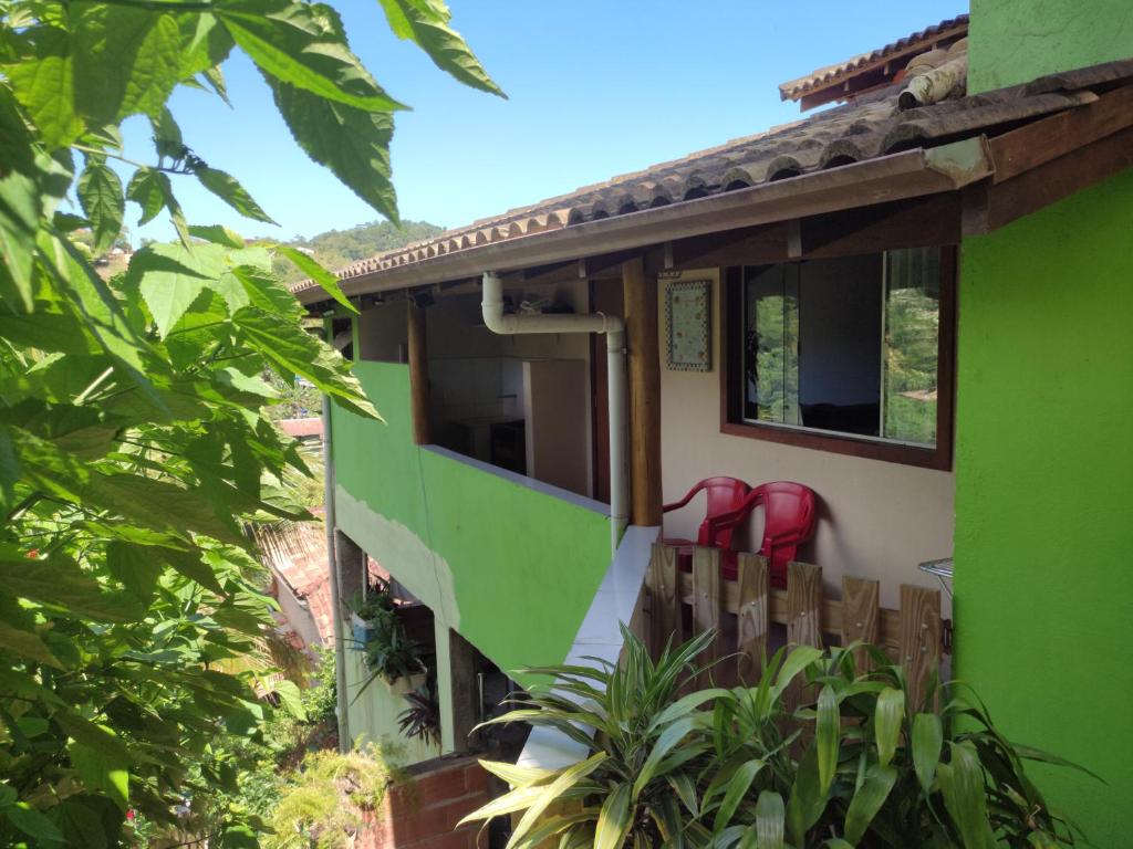 una casa con sillas rojas en el balcón en Casa em Ilhabela SP en Ilhabela