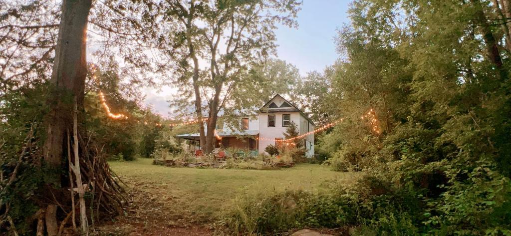 una casa en medio de un patio con árboles en The River Farmhouse, en Corbyville