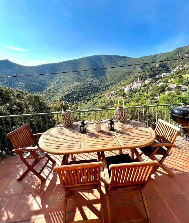 a wooden table and chairs on a deck with a view at casa in Palasca