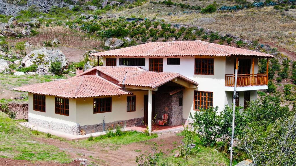 a house with a tile roof on a hill at casa flores in Ollantaytambo