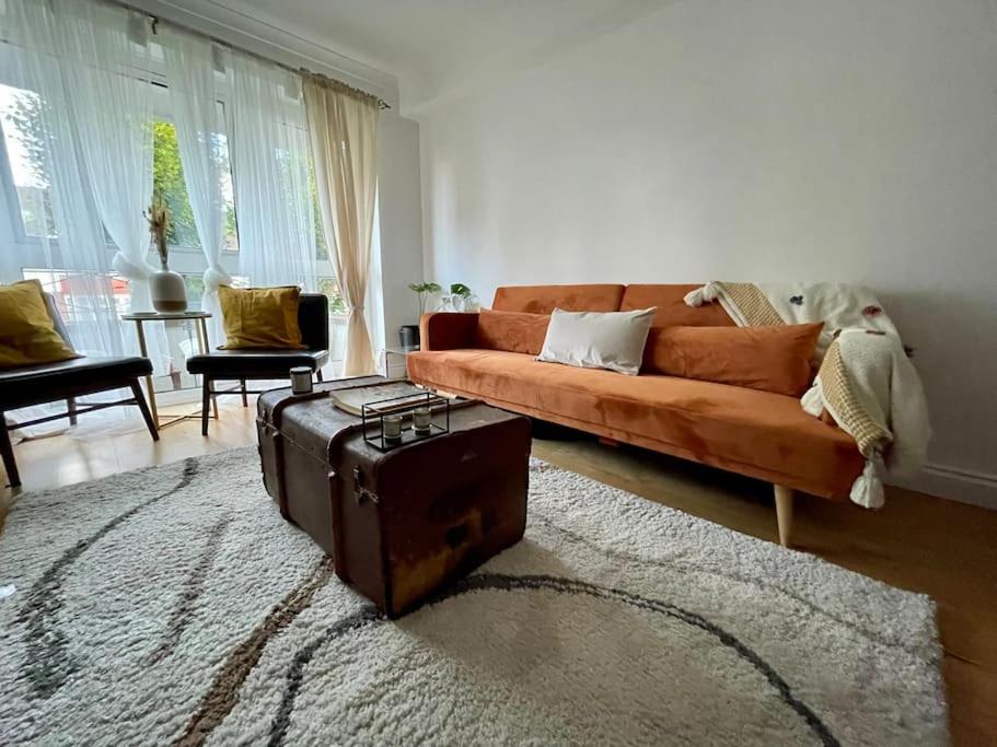 een woonkamer met een oranje bank en een tapijt bij Ealing Broadway bright flat in Ealing