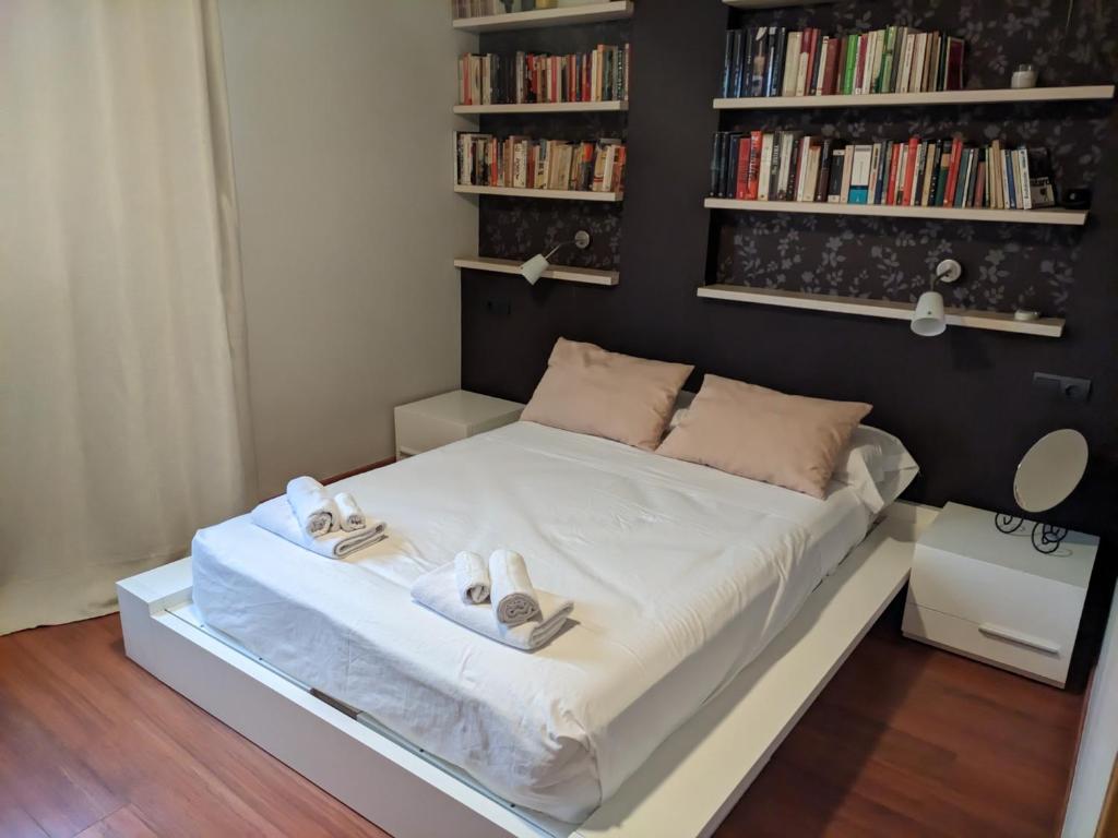 a small bedroom with a bed with towels and bookshelves at Casa del Doctor in Seville